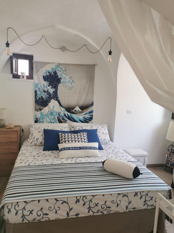 um quarto com uma cama com um quadro na parede em Casa DiLù em Sannicola