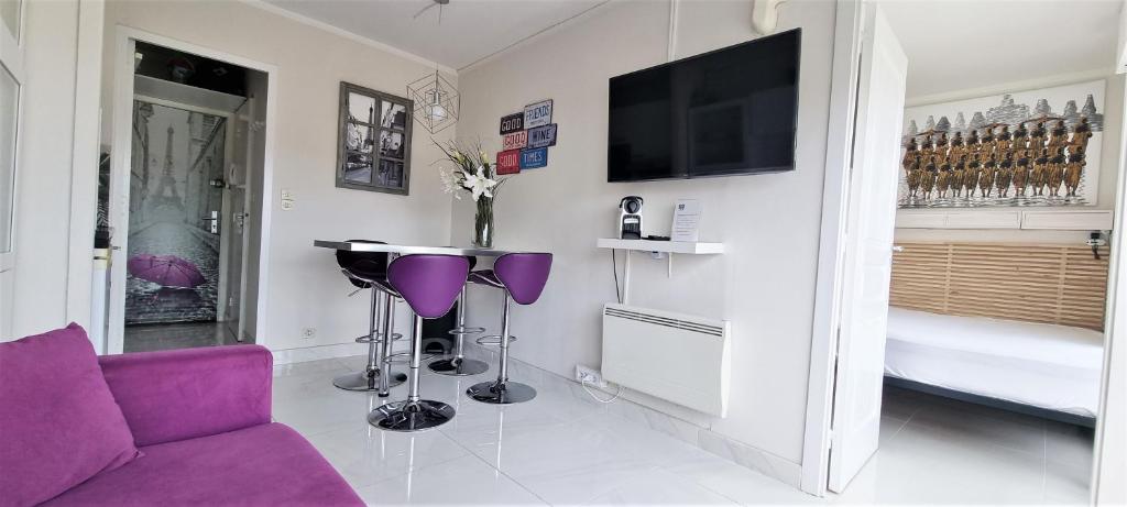 un salon avec un canapé violet et une télévision dans l'établissement Affitto-Nizza, à Nice