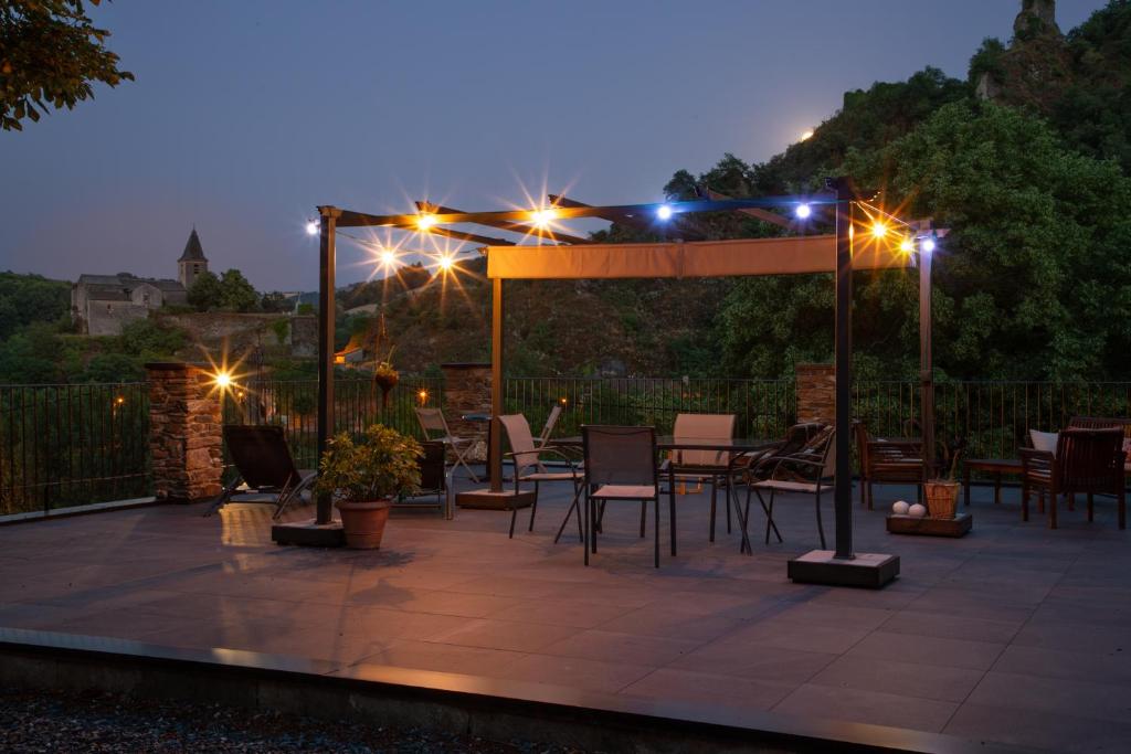 a patio with a table and chairs at night at Gîte de la Moulinquié in Saint-Cirgue