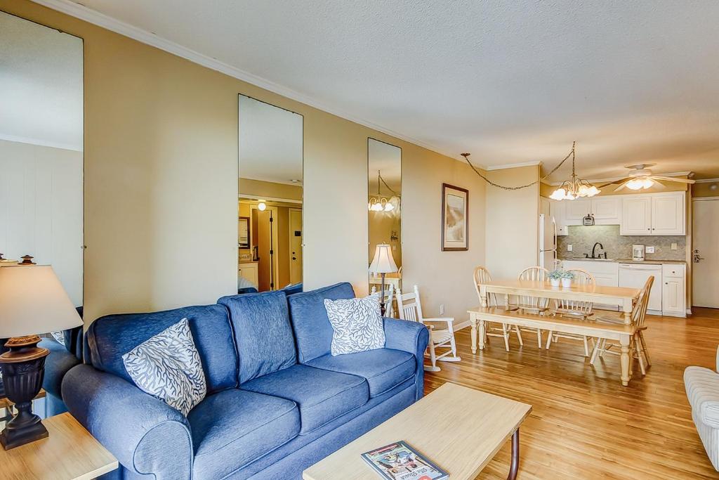 ein Wohnzimmer mit einem blauen Sofa und einem Tisch in der Unterkunft Sea Cabin 214 in Myrtle Beach