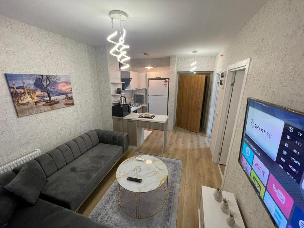 ein Wohnzimmer mit Couch und Tisch und eine Küche in der Unterkunft Classic Suite SH17 in Esenyurt
