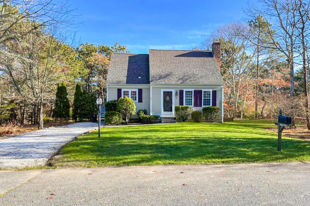 a white house with a yard with a driveway at Dream Dennis Getaway in Dennis