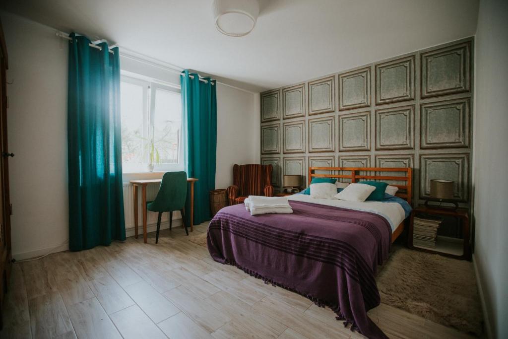 sypialnia z dużym łóżkiem z niebieskimi zasłonami w obiekcie Domek przy winnicy 