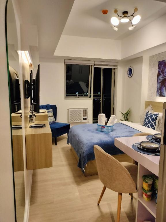 Il comprend une chambre avec un lit, un bureau et une cuisine. dans l'établissement Azure North Monaco Tower Unit 1930, à Lagundi