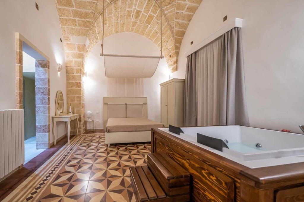 Corte Janca في Montesano Salentino: حمام كبير مع حوض استحمام وسرير