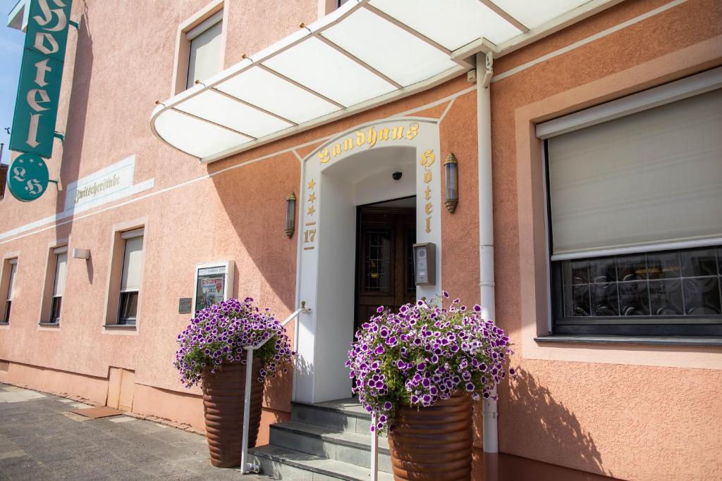 a building with two potted plants in front of it at Landhaus Hotel Neuss in Neuss