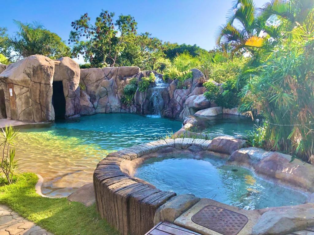 a pool of water with a waterfall in a garden at Pousada Caminho Das Cachoeiras in Sao Jorge