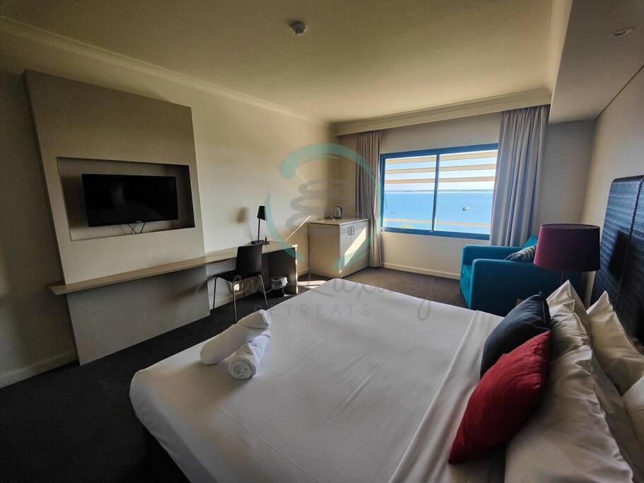 A television and/or entertainment centre at ZEN88 ESPLANADE: Hotel Suite w/ Ocean/Sunset Views