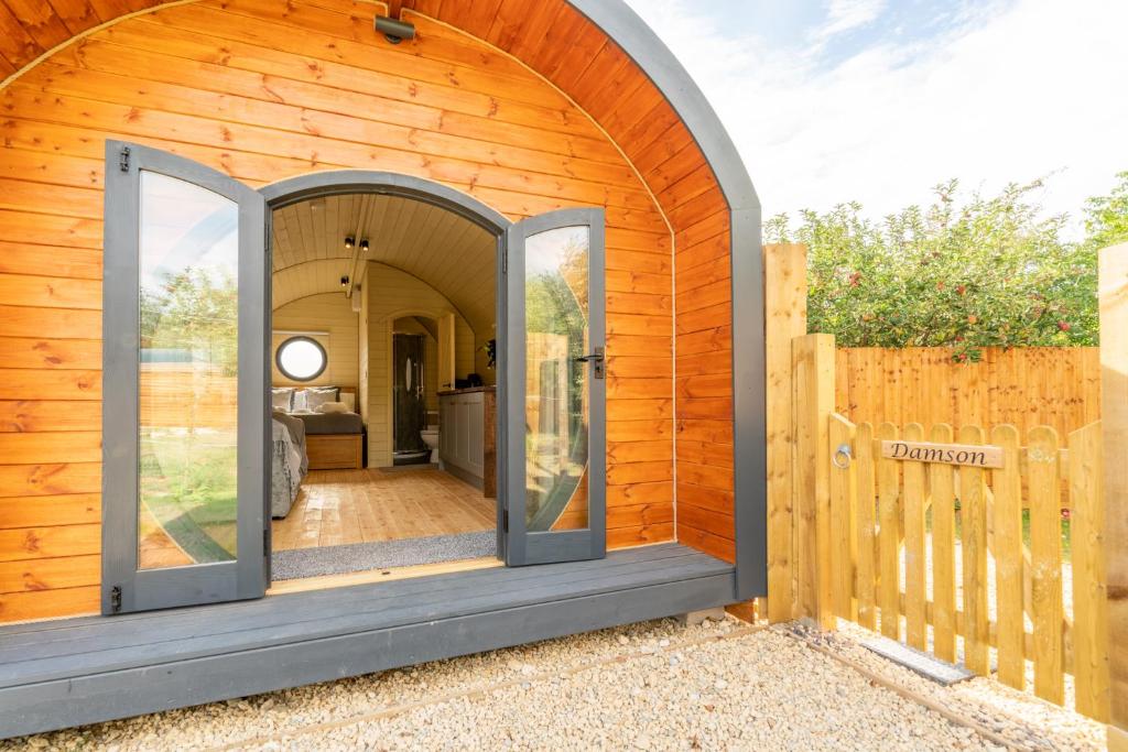 a wooden house with a large arched doorway at Laburnum Farm Estate in Alderton