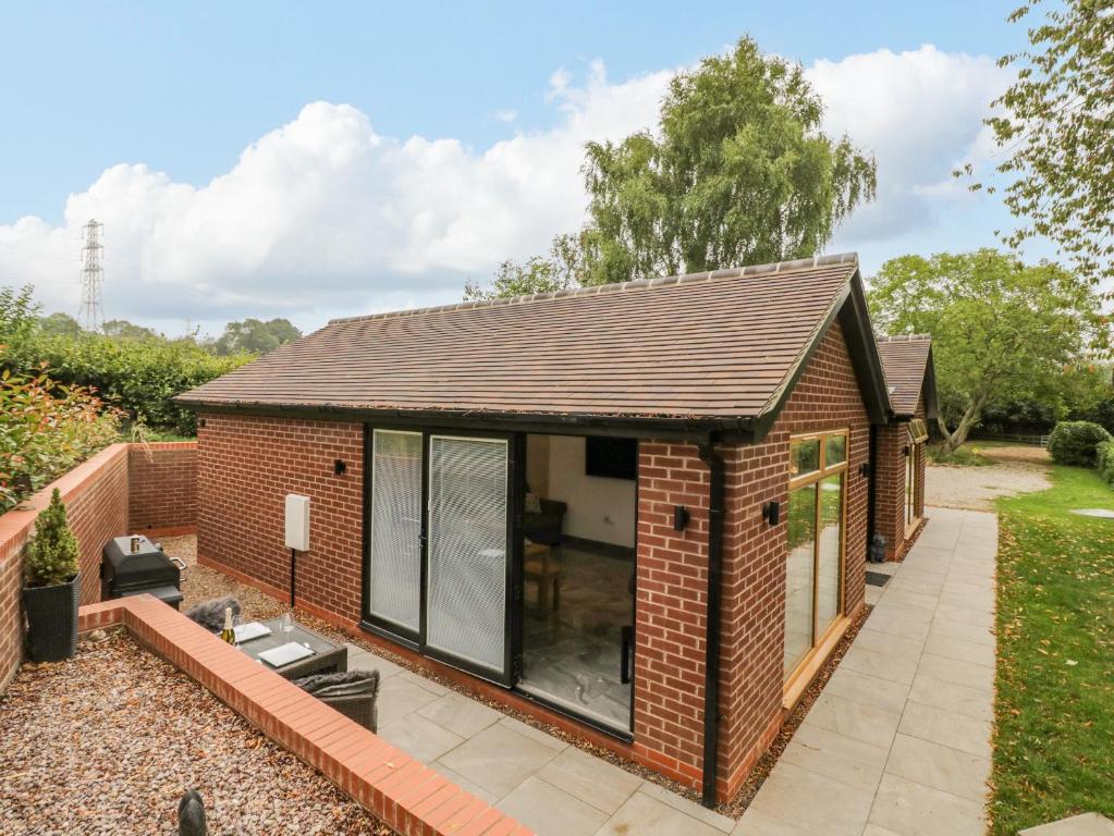 a brick house with a large glass extension at Hollywell Cottage in Lichfield