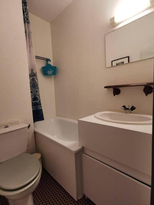 um banheiro branco com um vaso sanitário e uma pia em Joli studio vue sur les montagnes avec balcon em Cauterets