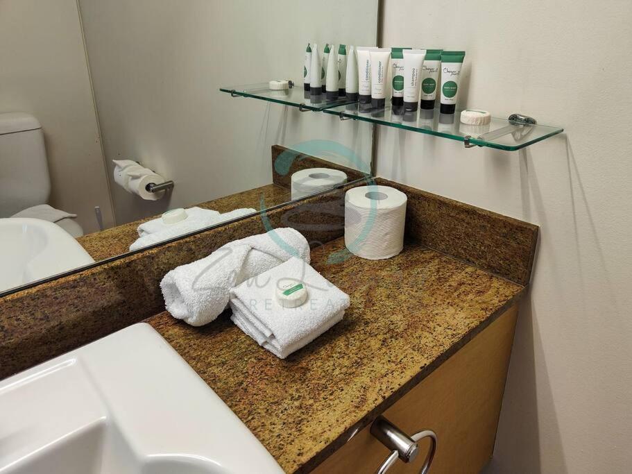 baño con lavabo y encimera con toallas en ZEN88 ESPLANADE: 1-BR Top Floor Ocean View Suite, en Darwin