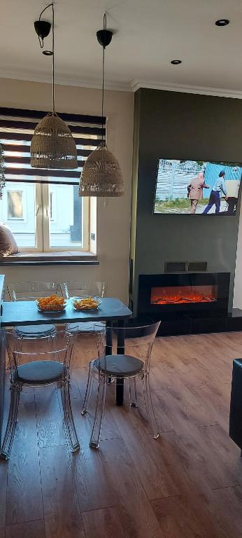 a dining room with a blue table and chairs and a fireplace at City Centre Apartment in Rēzekne