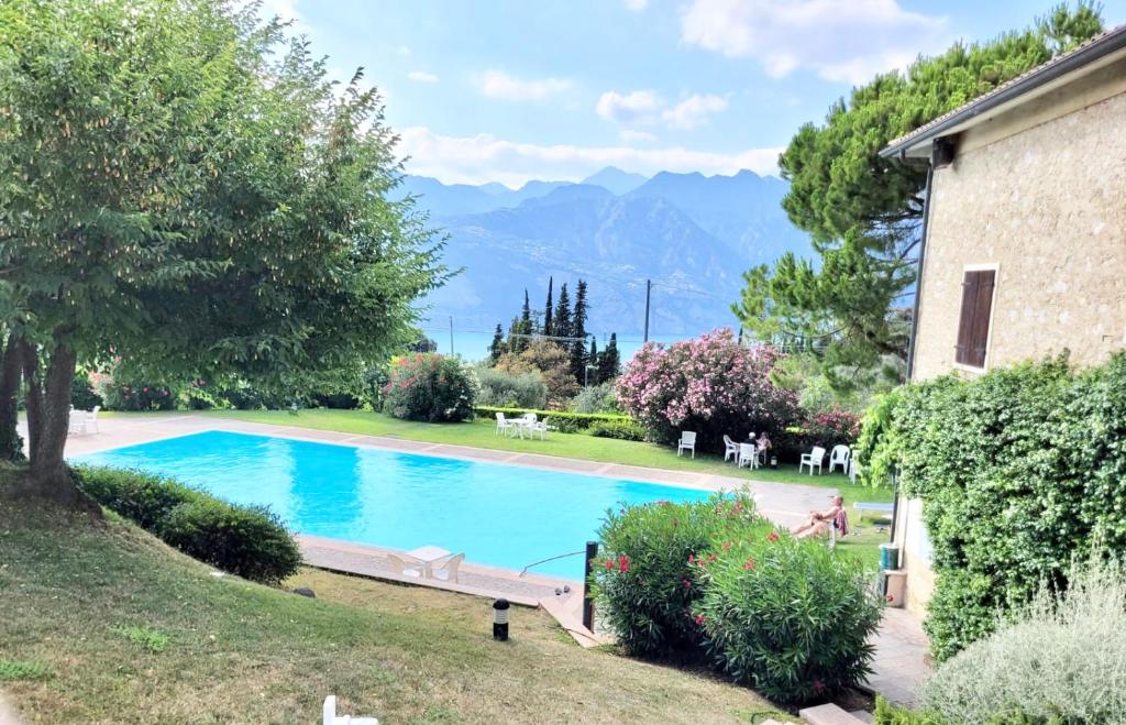 una piscina en un patio con montañas al fondo en Paradise Apartment Malcesine, en Malcesine