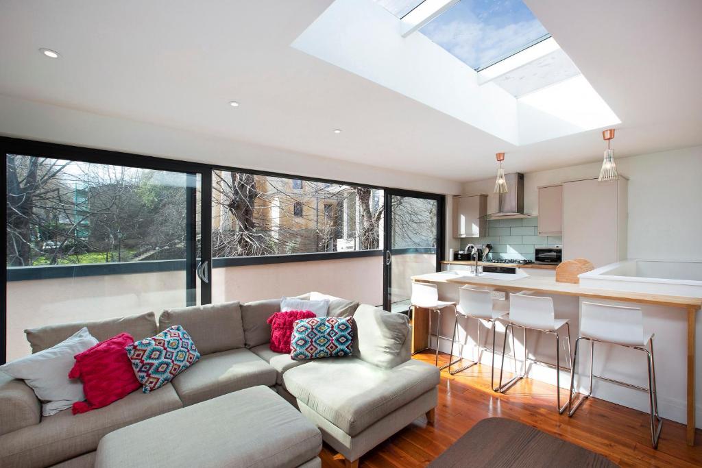 a living room with a couch and a kitchen at Large family, city centre Coach House in Bristol