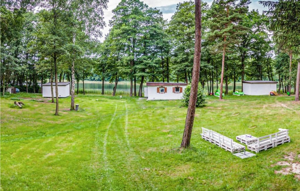 ein Park mit zwei Bänken auf einem Feld mit Bäumen in der Unterkunft Awesome Home In Sulnowo With Sauna 