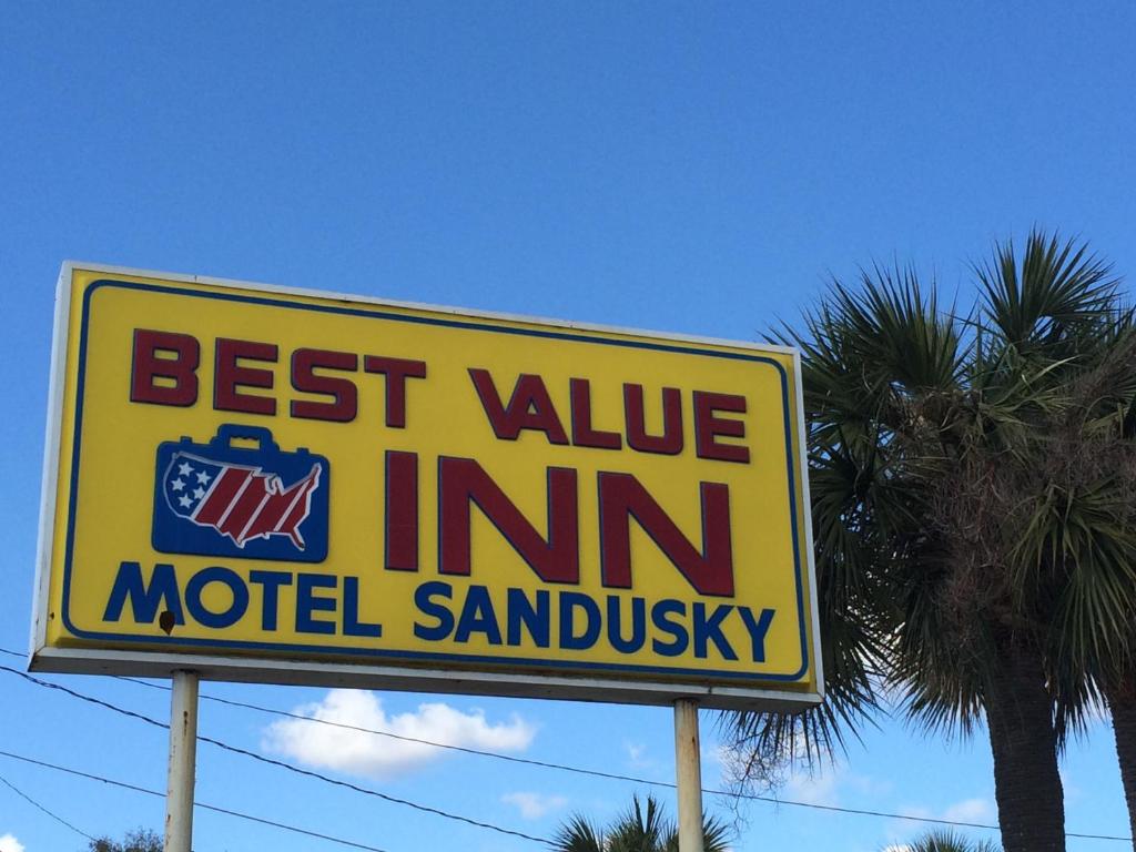 a best value inn sign in front of a palm tree at Best Value Inn Motel Sandusky in Marianna