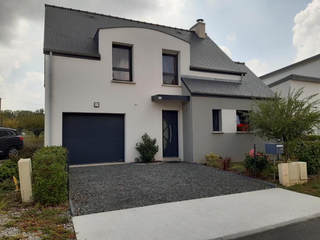 une maison blanche avec un garage dans l'établissement Kerlann Bruz, à Bruz