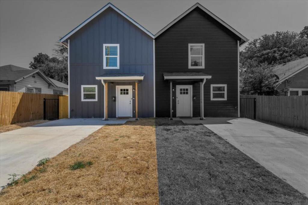 niebieski dom z dwoma białymi drzwiami i podjazdem w obiekcie The Duo A2 miles to Magnolia w mieście Waco