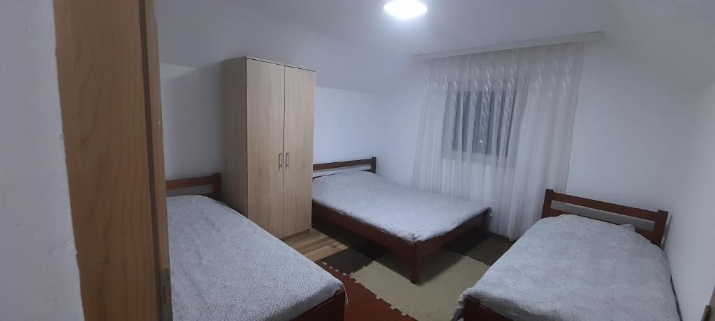 a small room with two twin beds and a cabinet at Breti's GuestHouse in Vusanje