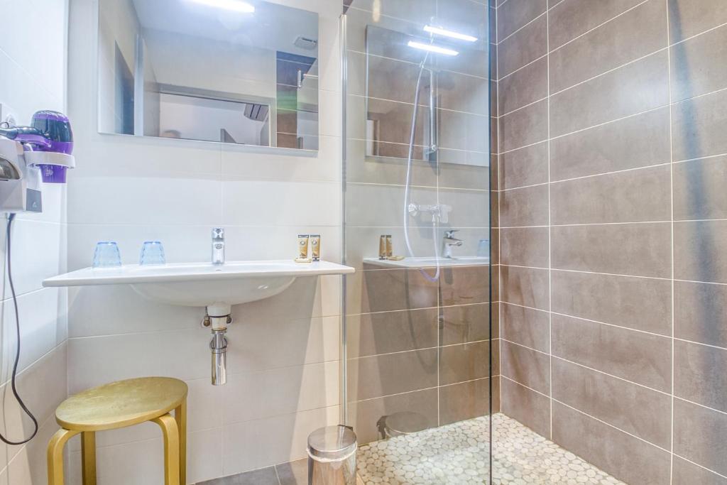 a bathroom with a sink and a shower at Hôtel Saint Albert in Sarlat-la-Canéda