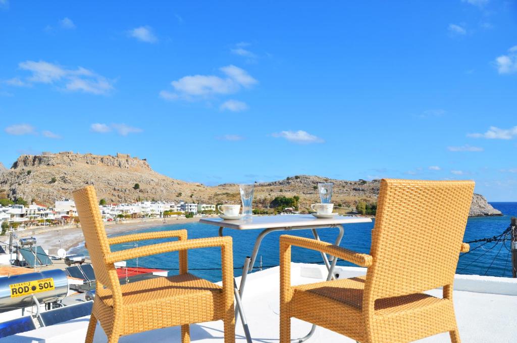 two chairs and a table on the deck of a boat at Georgias Apartments in Haraki