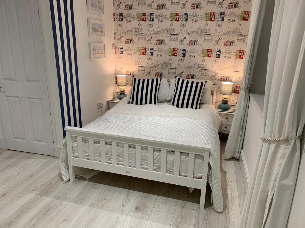 um pequeno quarto com uma cama branca e 2 almofadas em Coastal Joy - Room 1 em Newbiggin-by-the-Sea