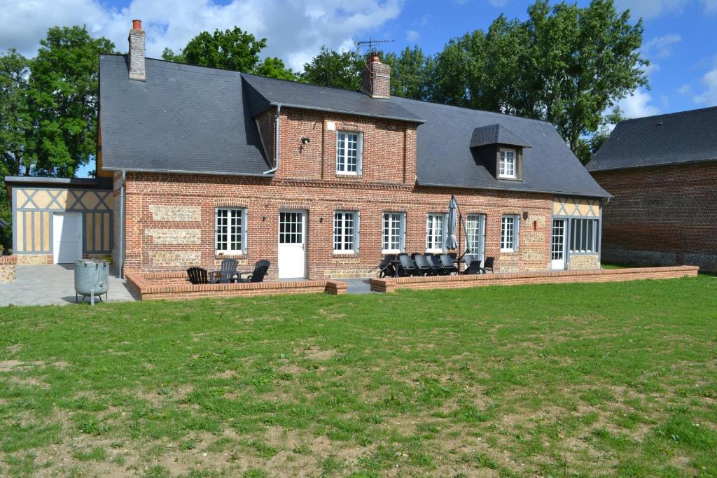 una grande casa in mattoni con un prato di fronte di La clef des champs a Doudeville