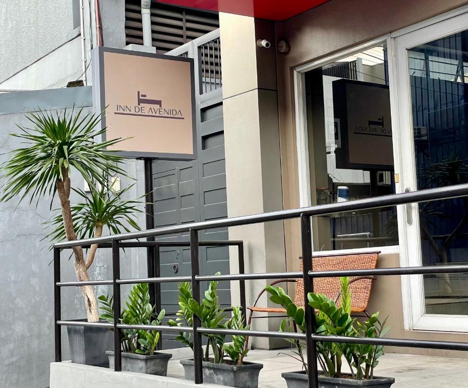 un balcon avec des plantes en pot devant un bâtiment dans l'établissement Inn De Avenida, Makati, à Manille