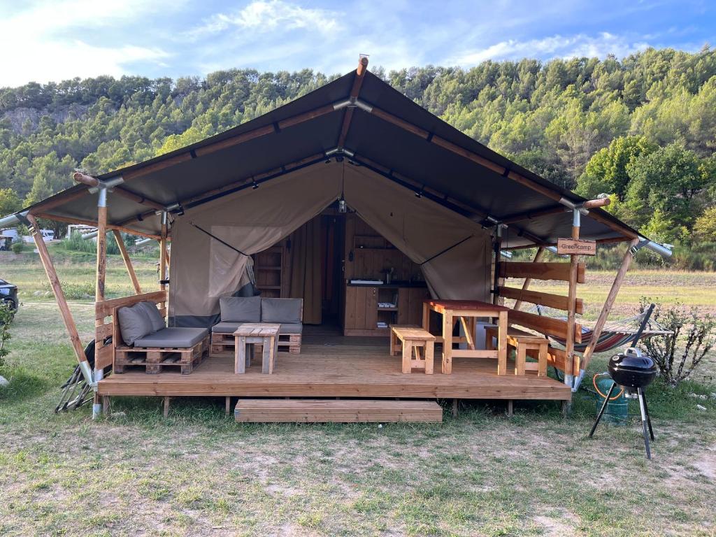 a tent with chairs and a grill in a field at le Moulin de Cost in Buis-les-Baronnies