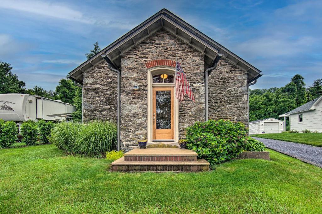 una casa de piedra con una bandera en la parte delantera en Cozy Wrightsville Cottage with Private Hot Tub!, en Wrightsville
