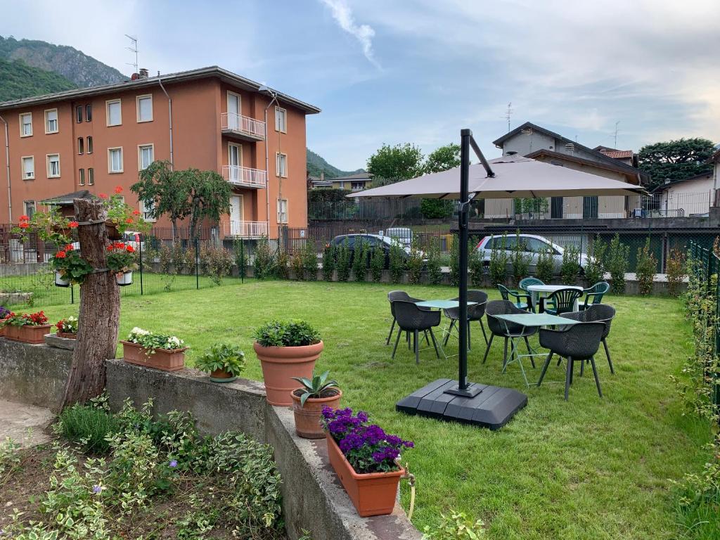 een tuin met een tafel en stoelen en een parasol bij Acchiappasogni Holiday House in Malgrate