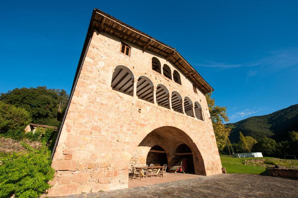 a brick building with a table and chairs in it at Casa Rural El Callís in Vall de Bianya
