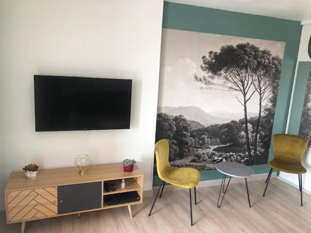 - un salon avec 2 chaises et une télévision murale dans l'établissement Superbe Studio tout confort Carro - Côte Bleue, à Martigues