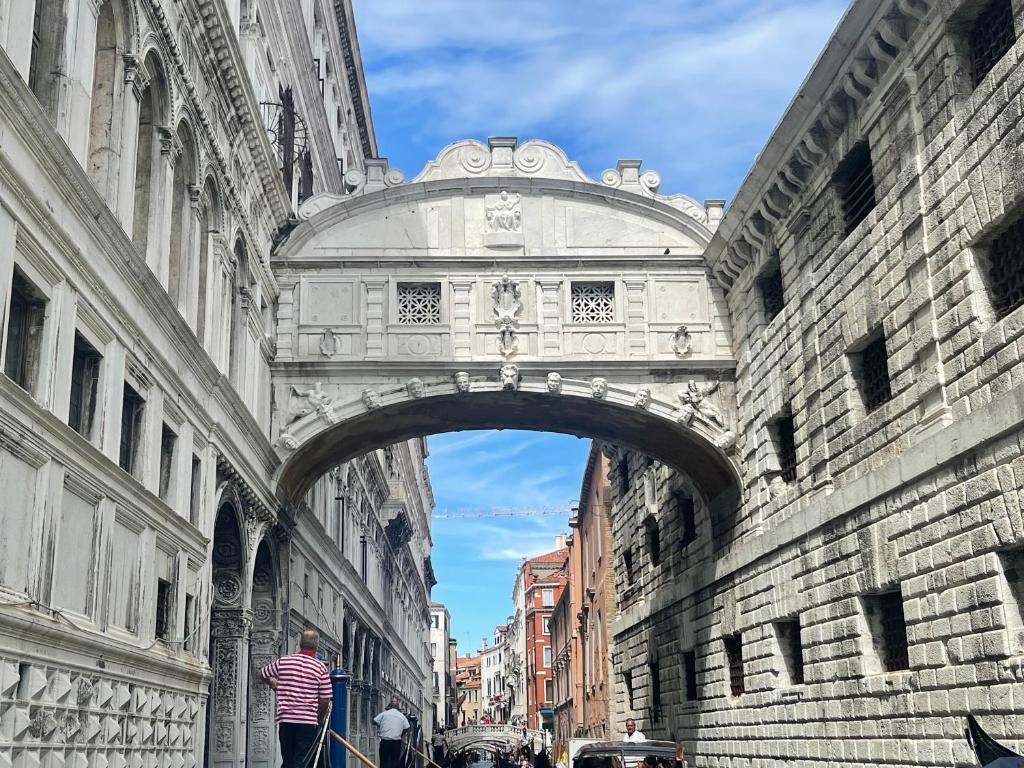 um arco num edifício com pessoas a andar por baixo dele em Ca' ai Sospiri em Veneza