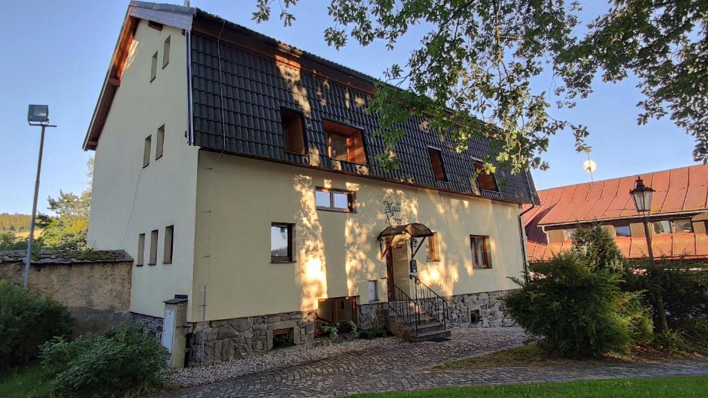 a large white building with a black roof at Mala Narnia in Frymburk