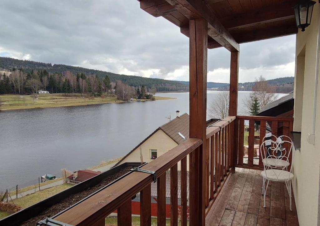 a balcony of a house with a view of a lake at Mala Narnia in Frymburk