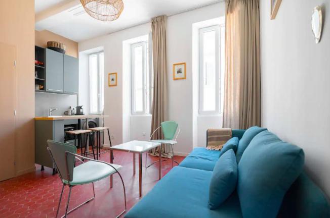 STUDIO ** HYPER CENTRE ** COEUR NOAILLES في مارسيليا: غرفة معيشة مع أريكة وكراسي زرقاء