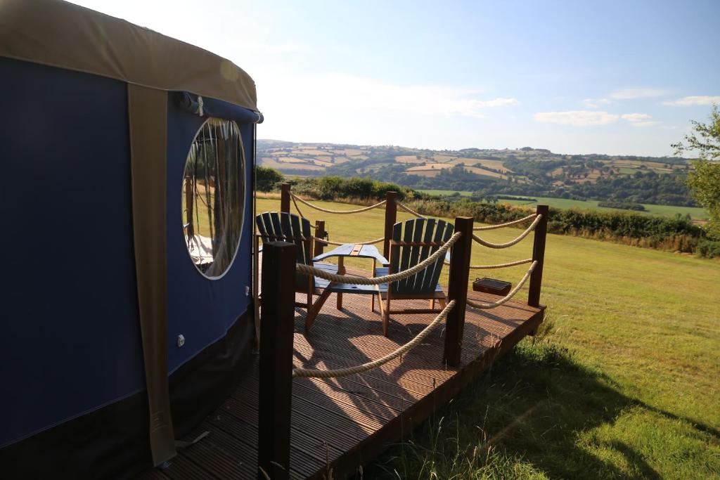 a patio with two chairs and a table on a trailer at Heart of the Wye in Clifford