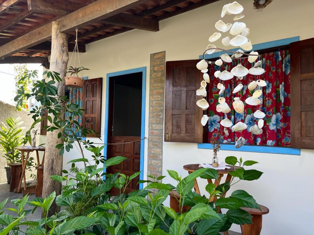 un patio con una mesa y una pared con platos en Pousada Casa de Naue - Ilha de Boipeba, en Isla de Boipeba