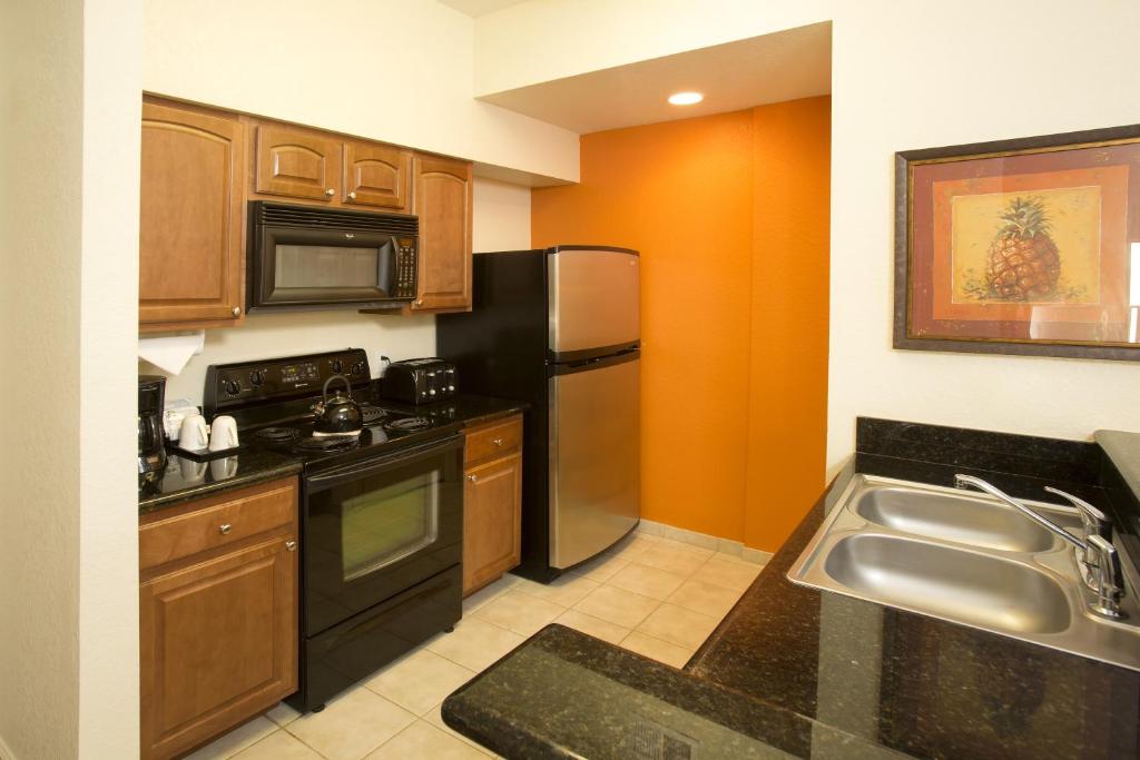 a kitchen with a stainless steel refrigerator and a sink at Lake Buena Vista Resort Village and Spa, Near Disney in Orlando