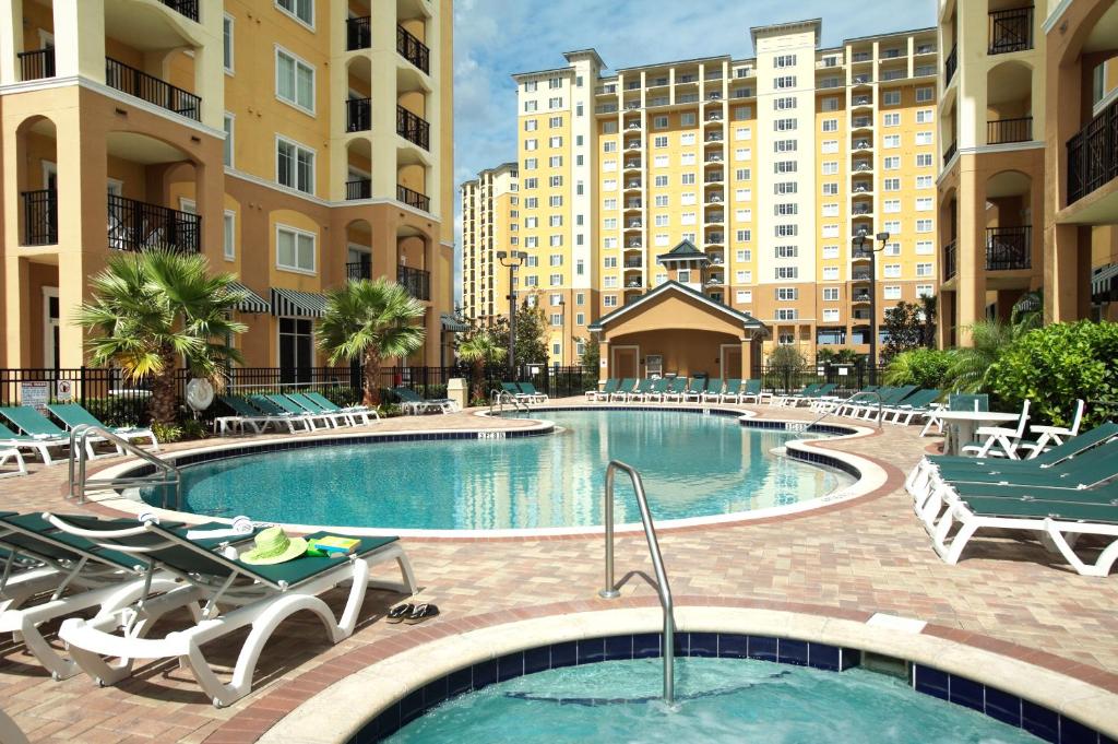 a swimming pool in a hotel with chairs and tables at Lake Buena Vista Resort Village and Spa, Near Disney in Orlando
