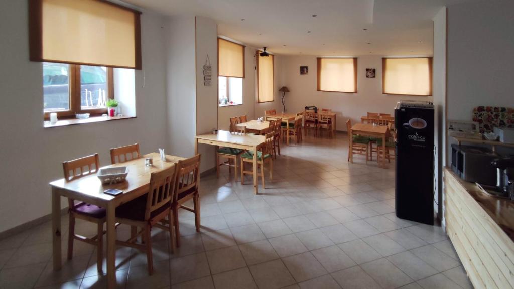 a dining room with tables and chairs and windows at Mala Narnia in Frymburk