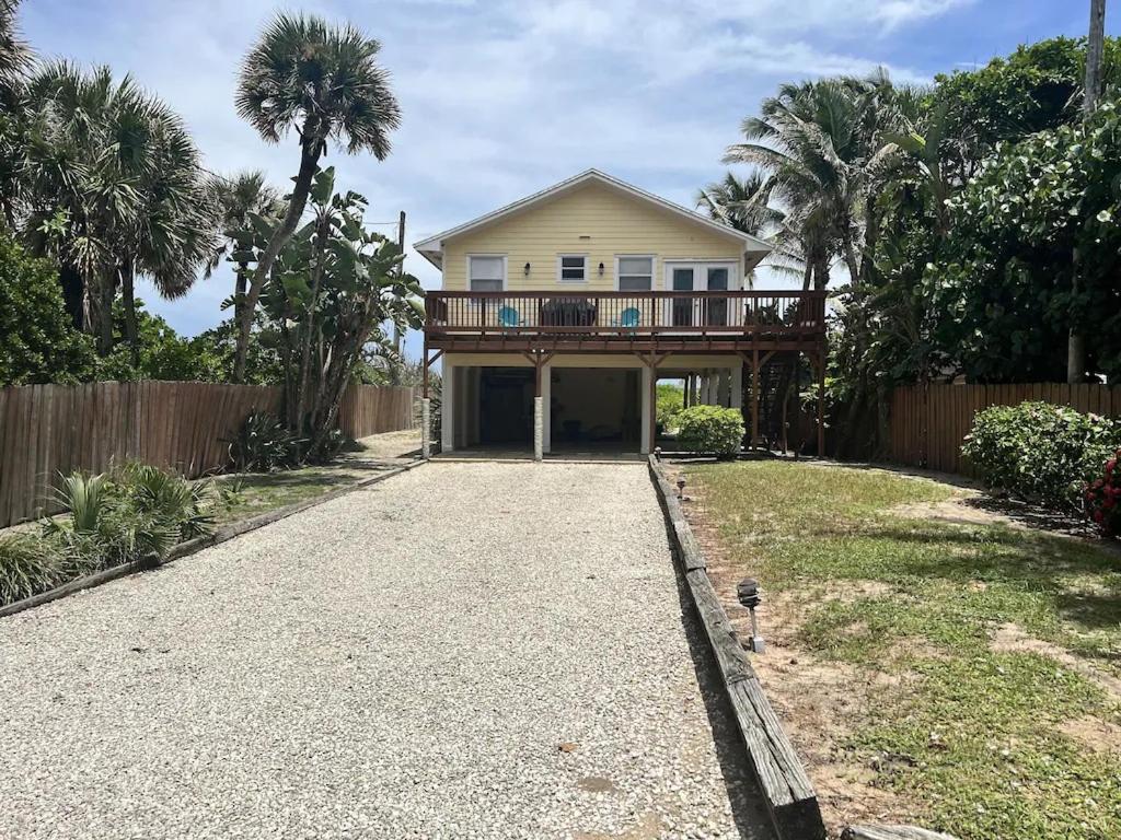 a house with a balcony and a driveway at Comfy Beach House on Vero Beach in Vero Beach