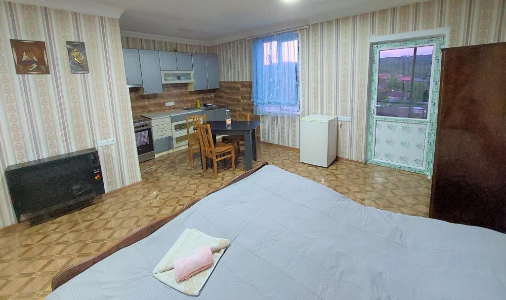 a bedroom with a large bed and a kitchen at Apartment BESO in Kutaisi