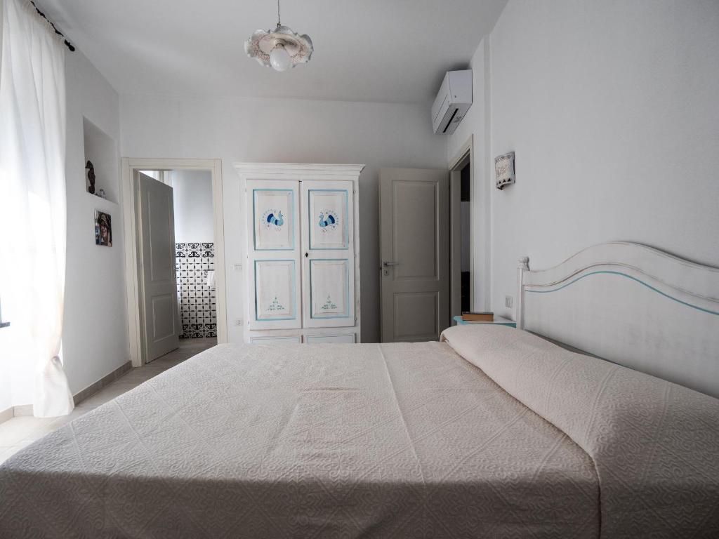 sypialnia z dużym łóżkiem w białym pokoju w obiekcie Affittacamere Solki w mieście SantʼAntìoco