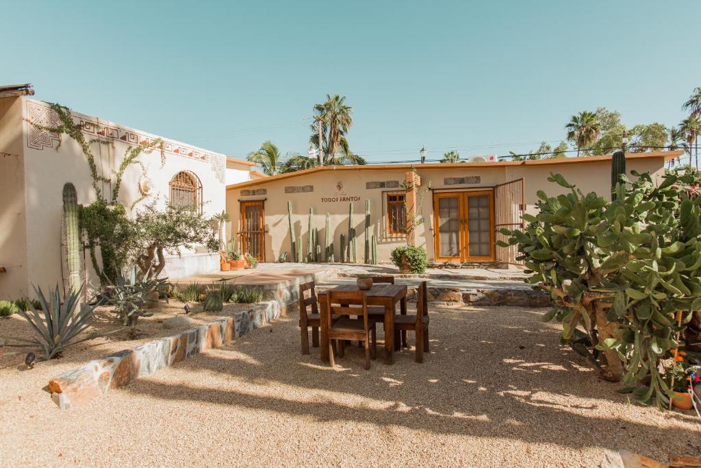 a house with a table and chairs in the yard at Cien Palmas- Authentic Mexican Casita 1 -Downtown in Todos Santos