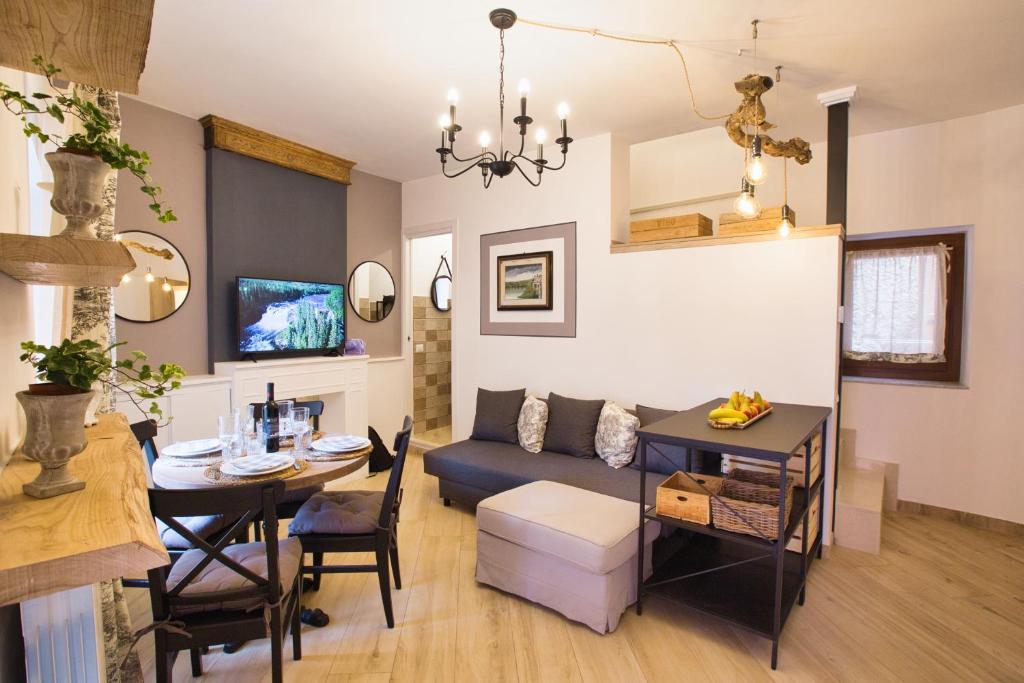 ein Wohnzimmer und ein Esszimmer mit einem Sofa und einem Tisch in der Unterkunft Cheerful and cosy home in beautiful Nemi in Nemi