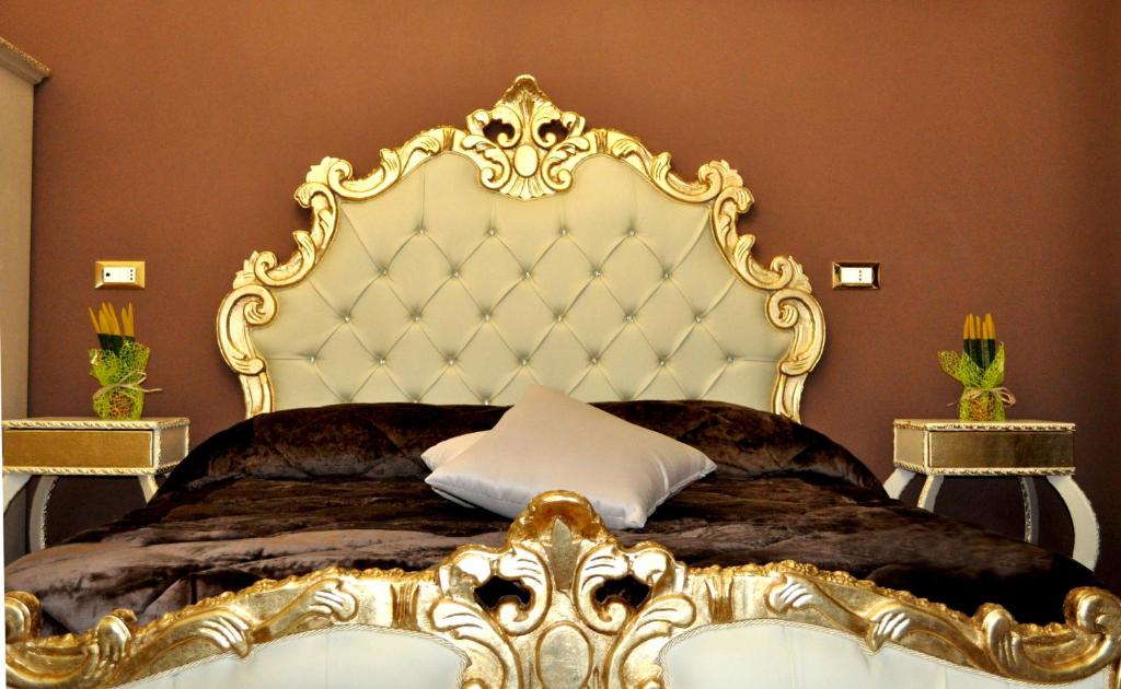 1 dormitorio con cama grande de oro y cabecero grande en Hotel des Artistes, en Nápoles