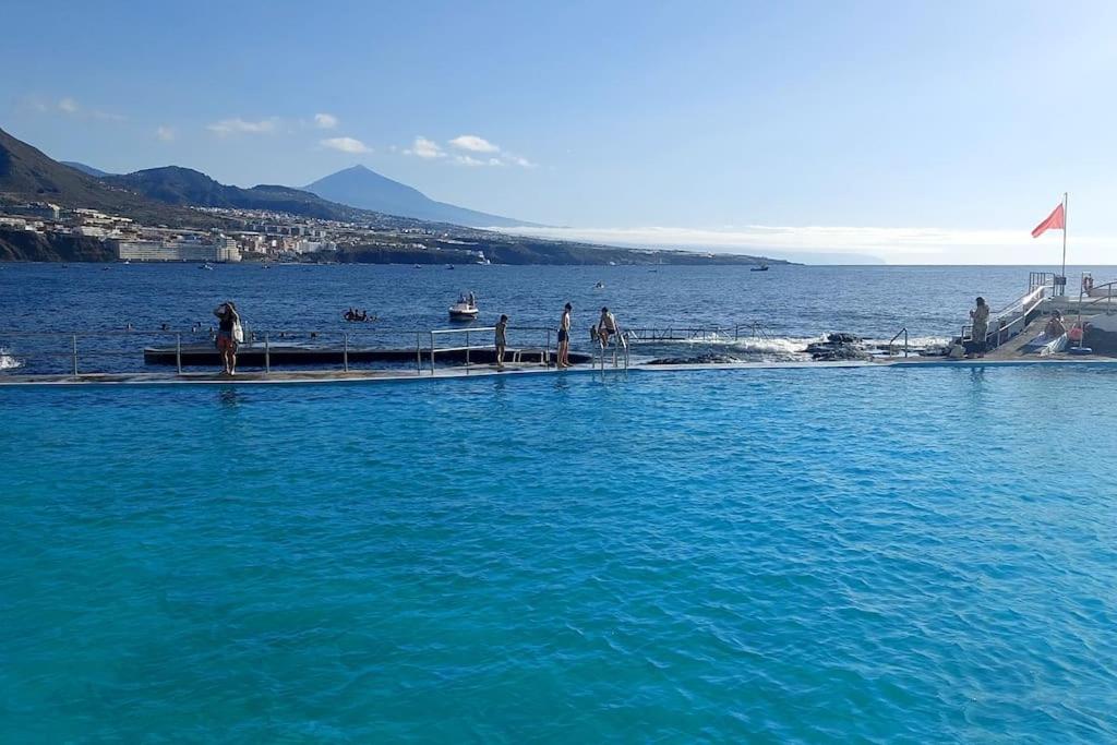 ein großes Gewässer mit Menschen auf einem Dock in der Unterkunft Altagay, apartamento con impresionantes vistas al mar y a El Teide in Punta del Hidalgo